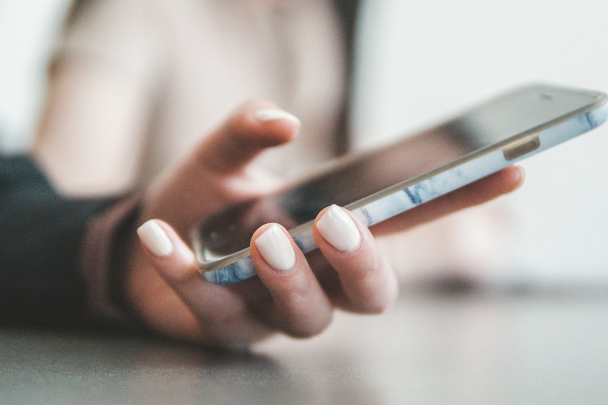 A hand holding a smartphone, about to send a reassuring text to a partner